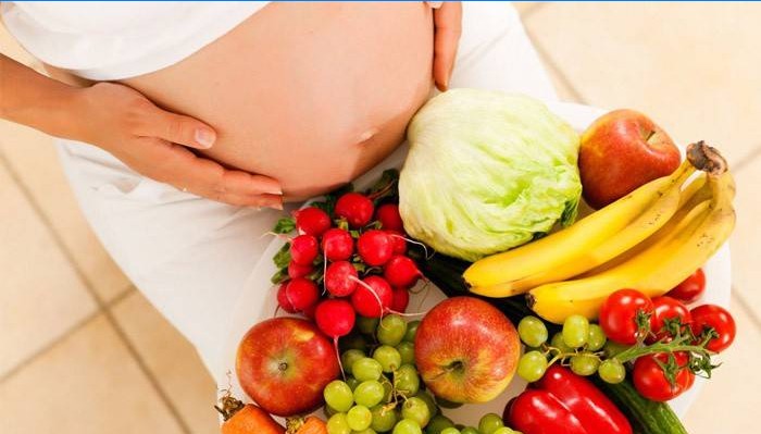 Těhotná žena se zeleninou a ovocem