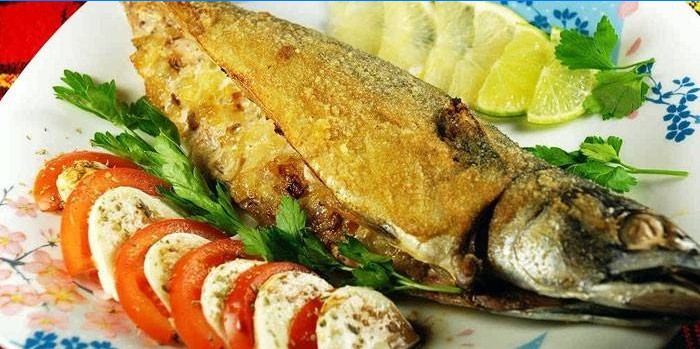 Plněná obalovaná makrela s caprese salátem na talíři