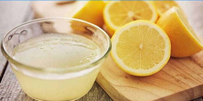 Citronová šťáva v misce a půl citronu