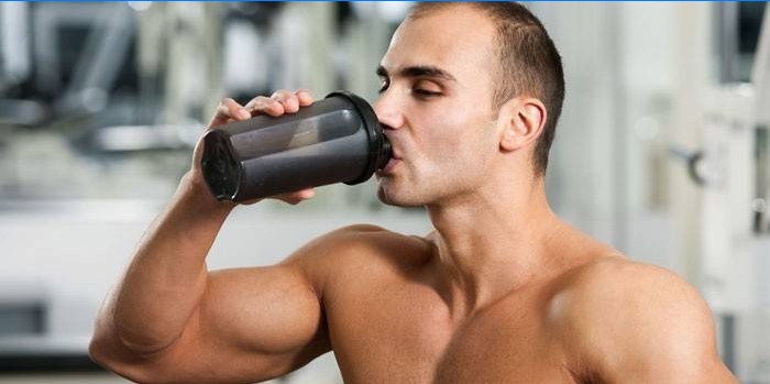 Člověk pije proteinový koktejl