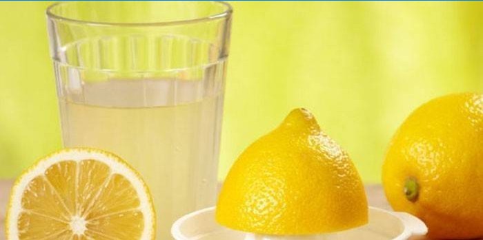 Citronová šťáva ve sklenici a citrony
