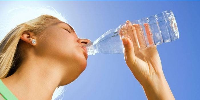 Dívka pije vodu z láhve