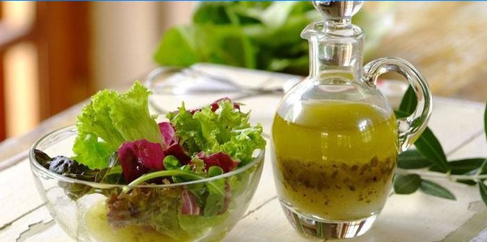 Listy salátu v misce a hotový dresink pro dresink