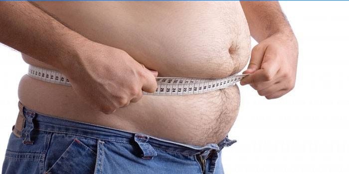 Muž měří centimetrem objem břicha