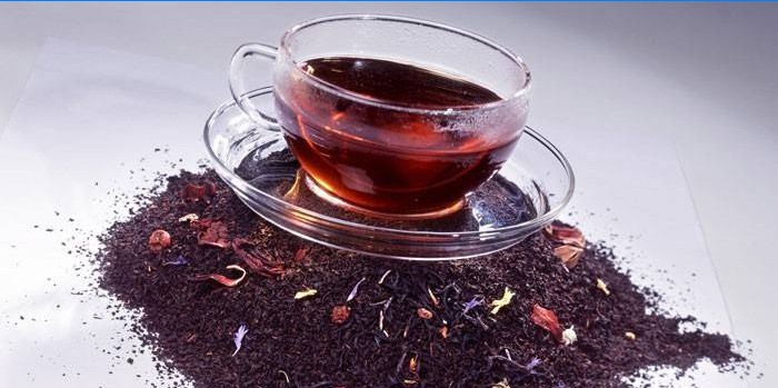 Šálek čaje na podložce suchého čaje