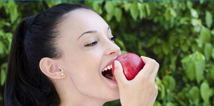 Dívka jí jablko