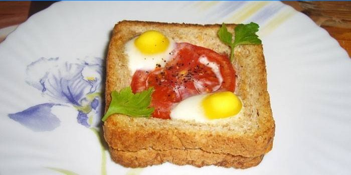 Horký sendvič s křepelčími vejci a rajčaty na talíři