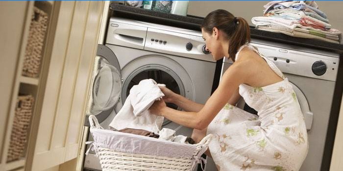Dívka dává ručníky do pračky