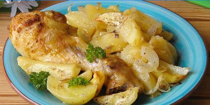 Kuřecí palička s bramborami a cibulí na talíři