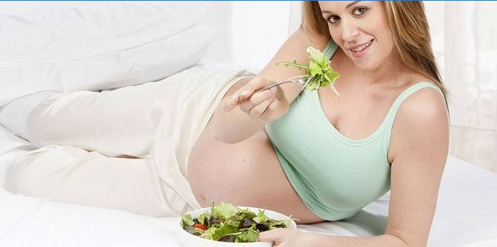Těhotná dívka jíst salát