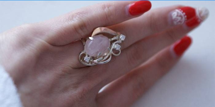 Zlatý prsten s růžovým křemenem na ženské ruce