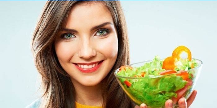 Dívka drží talíř se salátem