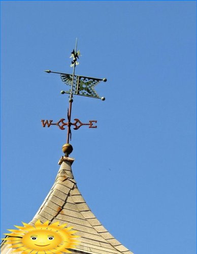 Větrná korouhvička na střeše domu