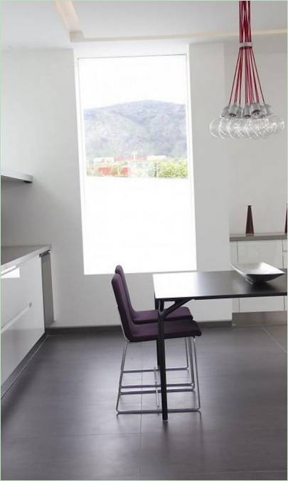Fialové židle a černý jídelní stůl v bílé kuchyni