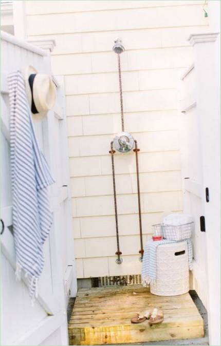 Bílá kabina a dřevěná sprchová vanička se skříňkou uvnitř