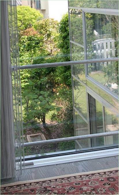 Okna zahradního domku s výhledem do dvora