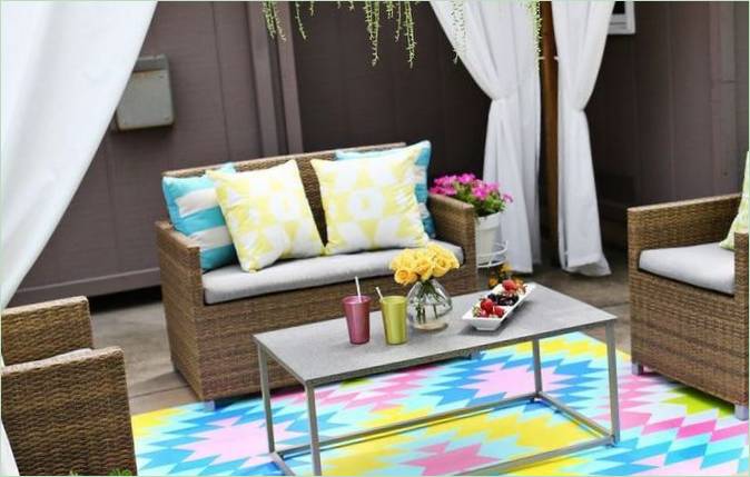 Design verandy s proutěným nábytkem a barevným kobercem