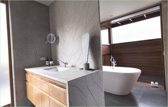 Interiér koupelny s kamennými a dřevěnými prvky ve výzdobě